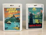 two boxes with posters on them sitting on a wooden table
