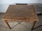 a small table with a wooden top on a tiled floor
