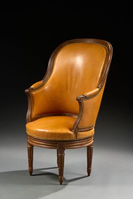 un fauteuil ancien en cuir, avec des pieds en bois et une assise rembourrée marron