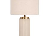 une lampe blanche avec un abat-jour beige posée sur une table
