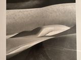black and white photograph of sand dunes in the desert under a cloudy sky
