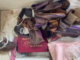 many pairs of shoes and a book on a bed