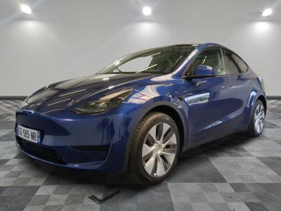 une Tesla Model Y bleue garée sur un sol à damier