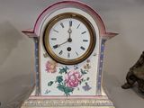 a clock that is sitting on a table next to a cat
