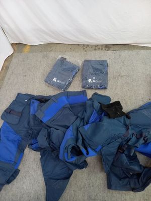 un tas de vêtements par terre, à côté d'un lit