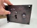 a person holding a key in a metal box