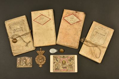 Plusieurs vieux livres sont posés sur une table, avec une étiquette dessus.