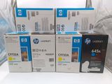 Quatre boîtes de cartouches de toner jaune HP 647a sont empilées les unes sur les autres