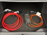 an image of a car trunk with two cables and a charger in it