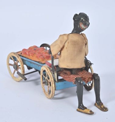 a figurine of a woman sitting on a cart with a basket of fruit
