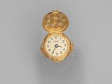a close up of a small gold watch on a white surface