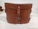 a brown leather box with a handle on a table
