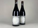 two bottles of wine sitting next to each other on a table