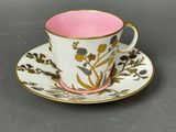 pink and white cup and saucer with a gold rim