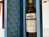 an open box with a bottle of whisky in it sitting on a table