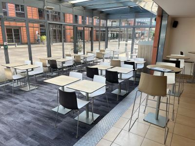 tables and chairs in a room with a large window