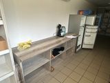 une petite cuisine équipée d'un réfrigérateur et d'étagères