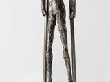 statue of a man holding a pair of skis on a wooden base