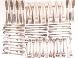 a lot of forks and spoons laid out on the table