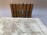 quatre livres sur une table sur laquelle se trouve une carte du monde