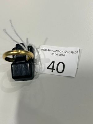 une bague noire et dorée, surmontée d'un anneau doré