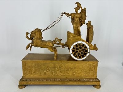 une statue en bronze représentant un homme conduisant une calèche tirée par un cheval