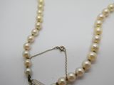 gros plan d'un collier de perles sur une surface blanche