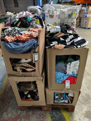 deux cartons sur lesquels sont posés des vêtements, dans un entrepôt