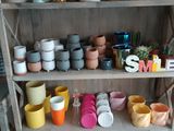 many pots and cups on a shelf in a room