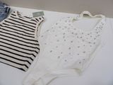 two bodysuits sitting on a white table next to a pair of shorts