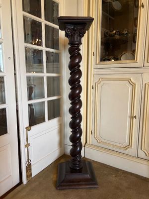 a tall wooden column in a living room with a glass door