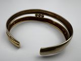 a close up of a gold cuff with a diamond on it