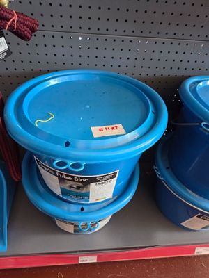 several blue buckets are on a shelf in a store