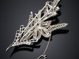 a close up of a silver broochle with a chain attached to it