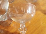 several empty wine glasses sitting on a table with a wooden surface
