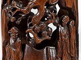 a wooden cup with carvings of people and animals on it