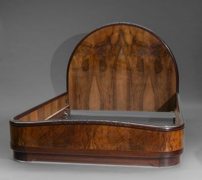 un lit ancien en bois avec une tête et un pied de lit incurvés
