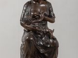 statue of a woman holding a cat on a table