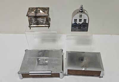 a small silver clock and a small silver box on a table