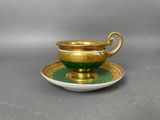 an image of a green and gold cup and saucer on a saucer