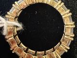a gold bracelet with a piece of yarn on top of it