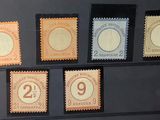cinq timbres différents présentés dans une vitrine, dont plusieurs exemplaires