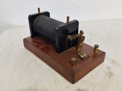 une vieille maquette de machine à vapeur posée sur un socle en bois