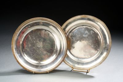 paire de plats plaqués argent sur un socle, posés sur un support gris