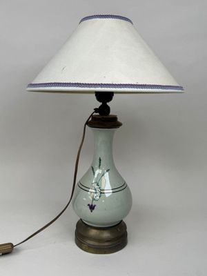 une lampe posée sur une table, avec un abat-jour blanc