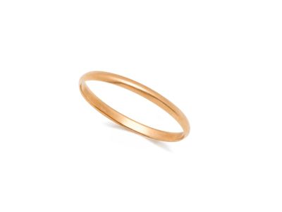 gros plan d'une bague en or sur fond blanc