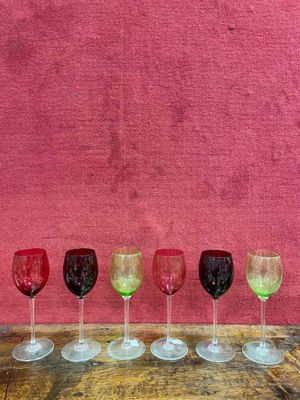 six verres à vin alignés sur une table en bois