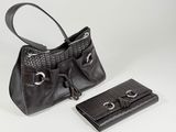 two pieces of black purses and a wallet on a white surface