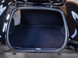 a black motorcycle with its trunk open in the back of a car