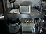 a small kitchen with a stove, oven, and pans on the counter